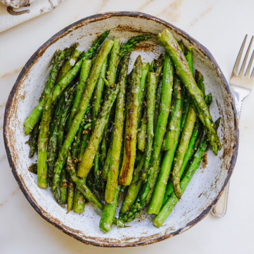 Pan fried asparagus recipe served on a rustic stoneware plate