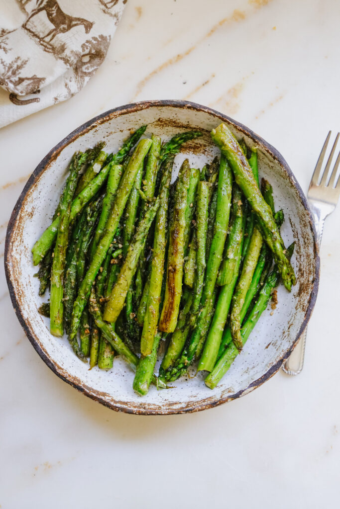 Pan fried asparagus recipe served on a rustic stoneware plate