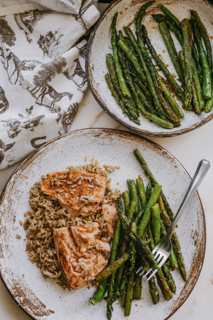 Pan fried asparagus served alongside salmon and rice for a complete dinner