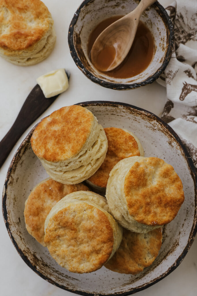Buttermilk biscuits on a plate with honey and butter