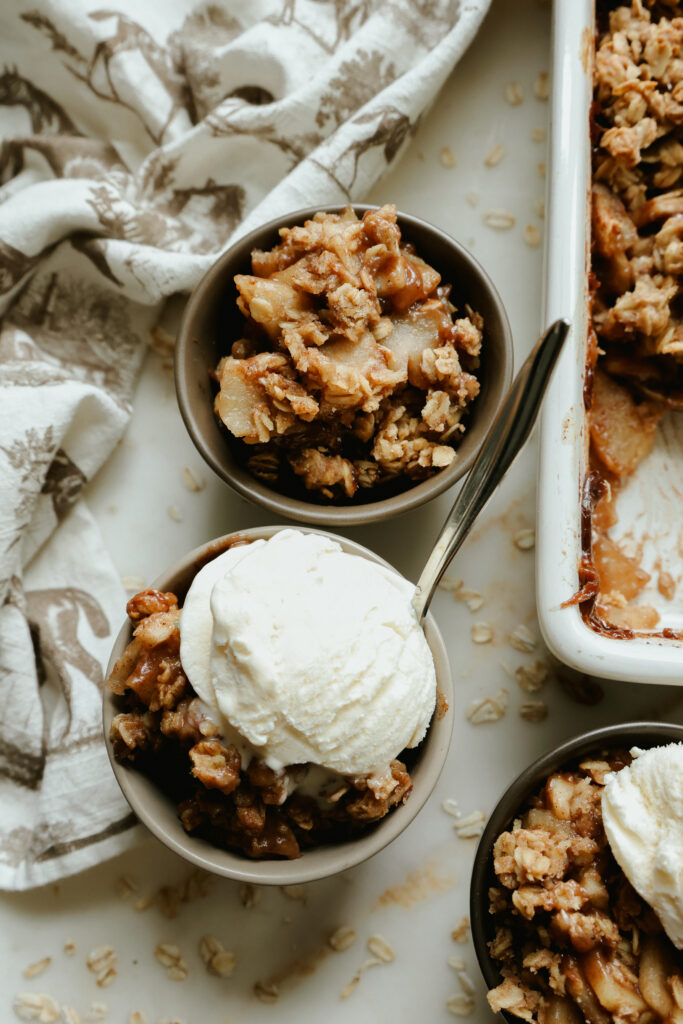 Healthy apple crisp topped with a scoop of vanilla ice cream