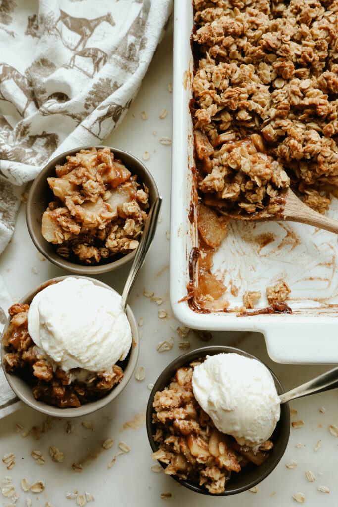 Healthy apple crisp with maple syrup topped with a scoop of vanilla ice cream
