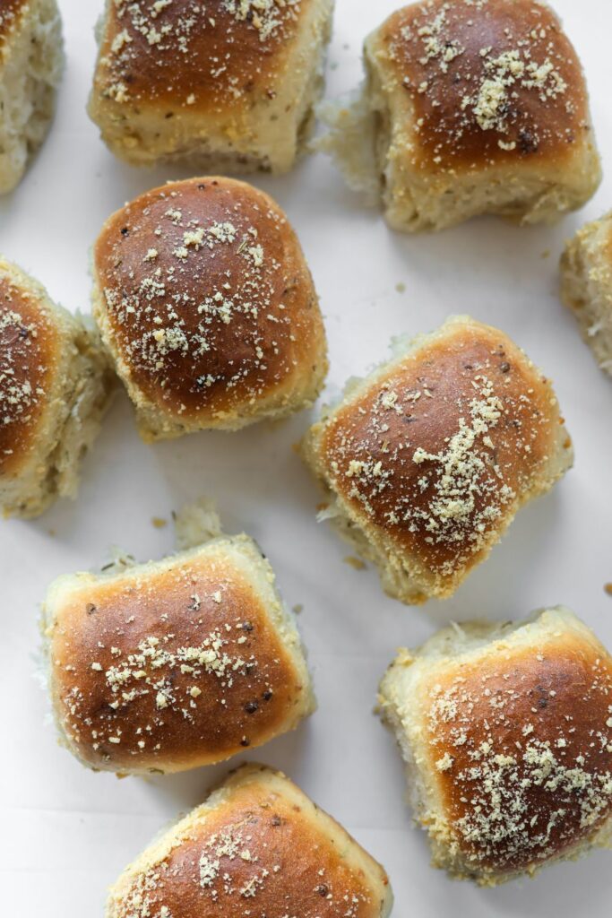 Golden brown rosemary garlic dinner rolls fresh from the oven, brushed with butter