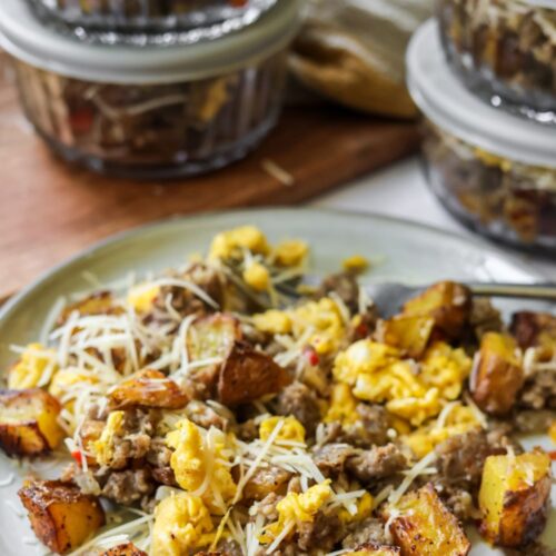 Easy breakfast bowl served warm with roasted potatoes, eggs, sausage, and freshly grated parmesan cheese