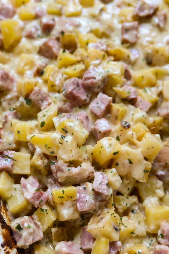 Baked ham and potato casserole in a glass casserole dish