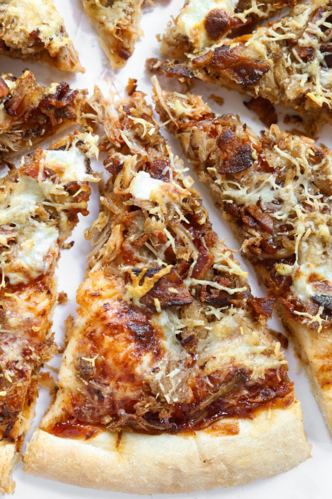 Slices of homemade BBQ pulled pork pizza with melted mozzarella and parmesan