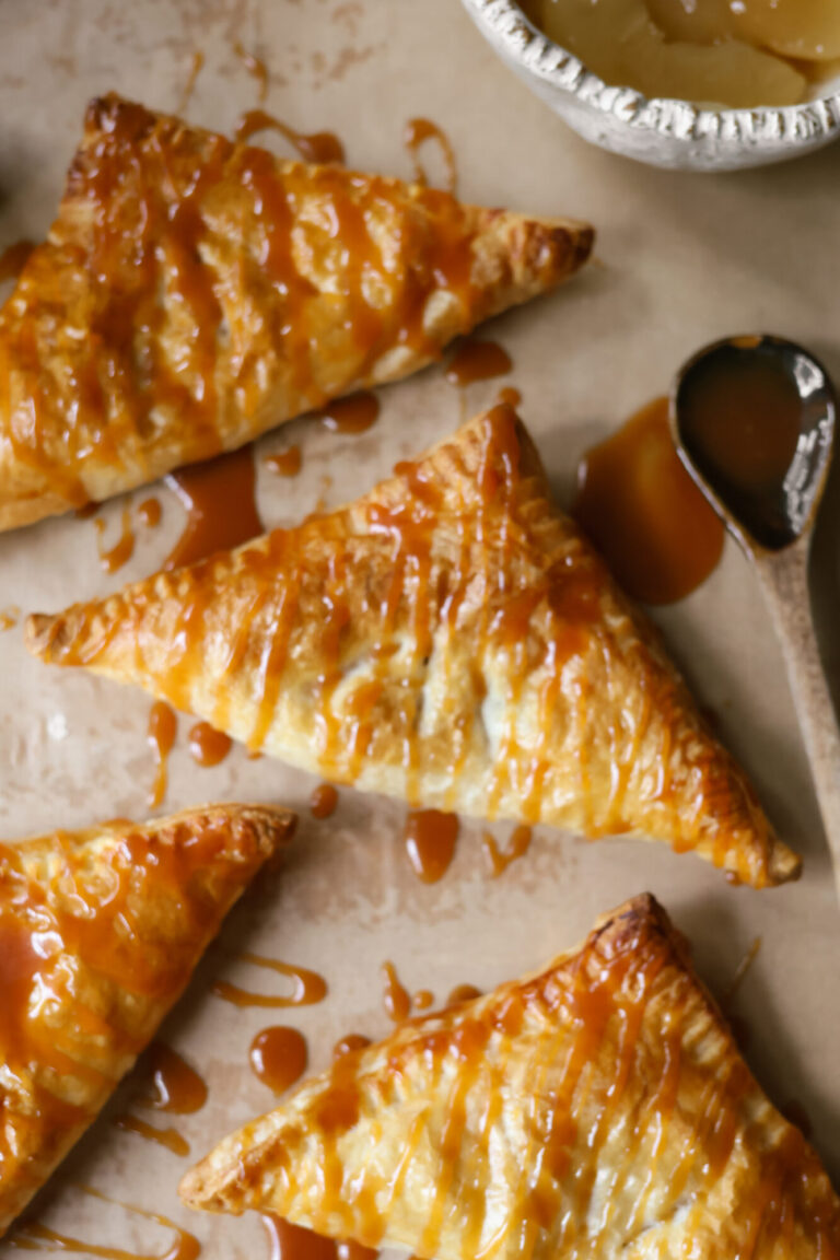 Flaky 3 ingredient apple turnovers with golden crust, filled with apple pie filling and drizzled with homemade caramel sauce.