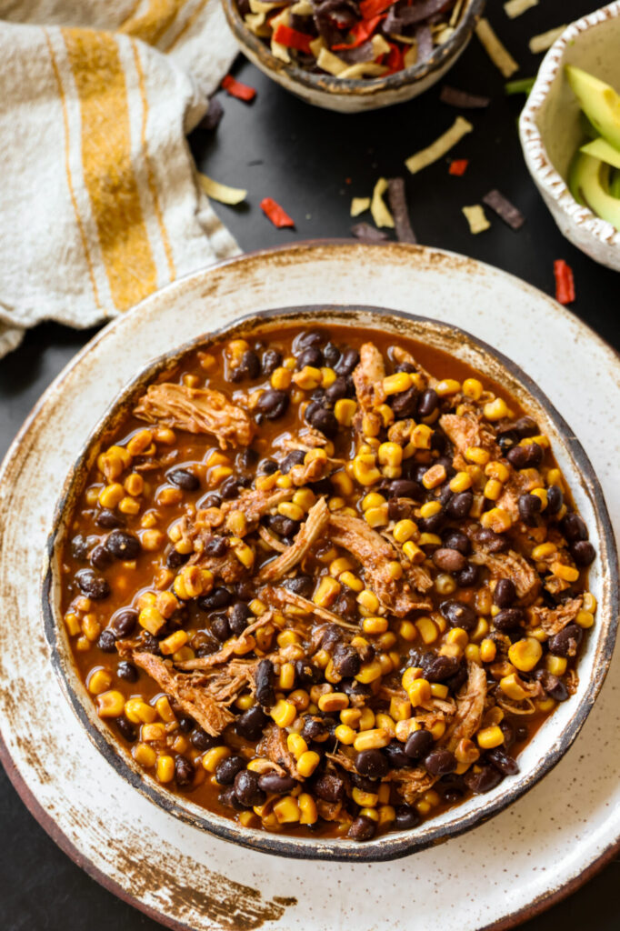 Slow cooker chicken enchilada soup served in a rustic bowl.