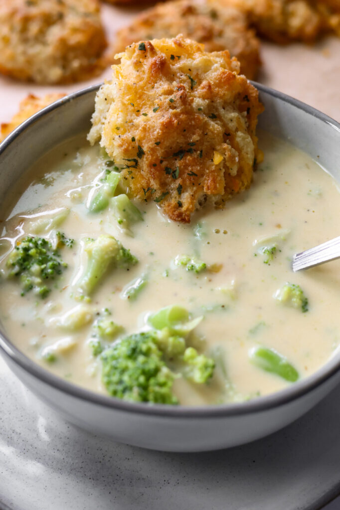 Homemade broccoli cheddar soup with heavy cream served in a white bowl.