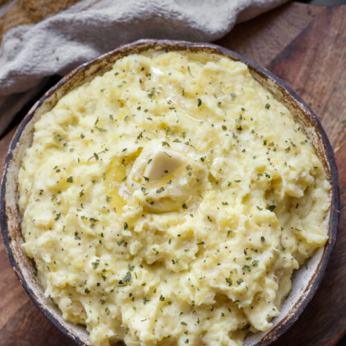 A bowl of creamy sour cream mashed potatoes made with Yukon Gold potatoes, butter, and milk — the perfect side dish for Thanksgiving dinner.