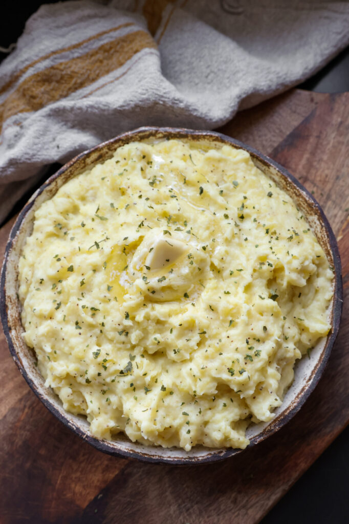 A bowl of creamy sour cream mashed potatoes made with Yukon Gold potatoes, butter, and milk — the perfect side dish for Thanksgiving dinner.