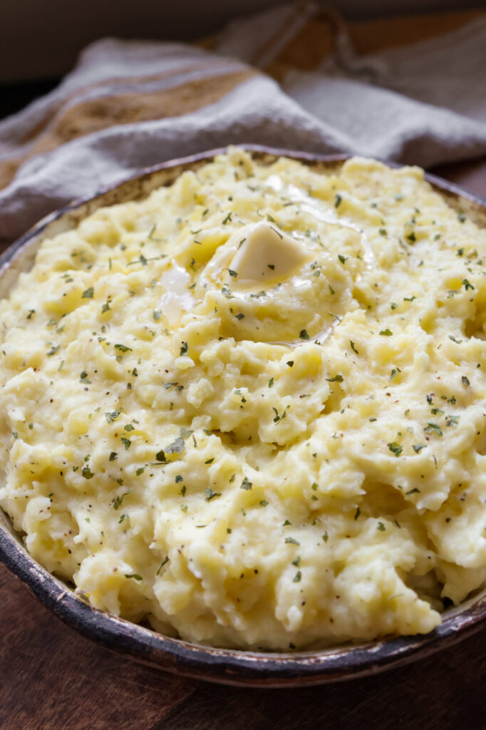 Homemade mashed potatoes with sour cream and butter, fluffy and rich in flavor, served in a rustic farmhouse bowl.