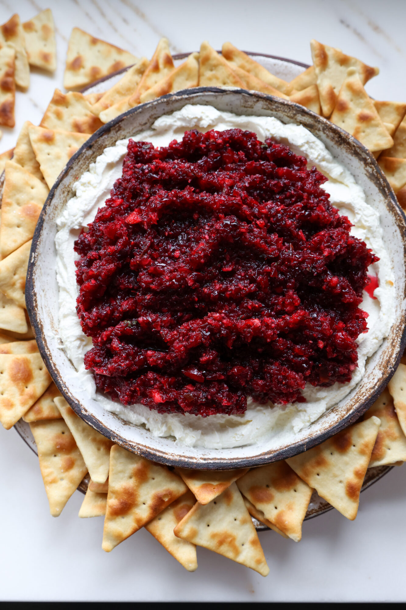 Creamy cranberry jalapeno dip served with crackers for a holiday appetizer.