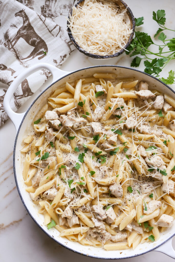 Creamy penne chicken Alfredo finished in a large skillet with fresh parsley