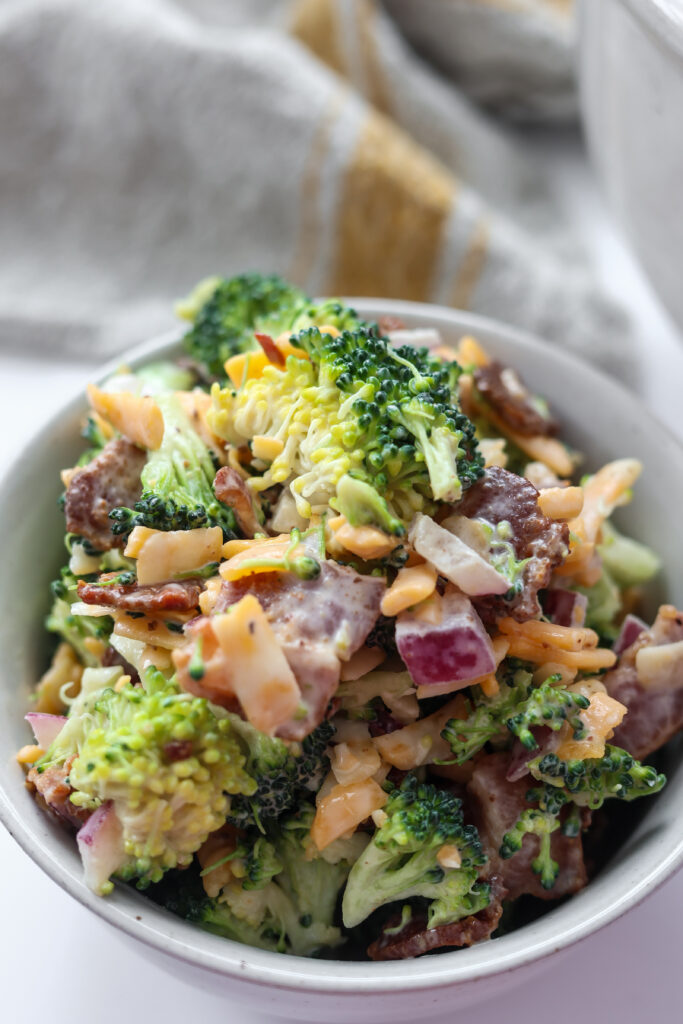 Easy broccoli salad recipe with crumbled bacon, shredded cheese, and creamy dressing.
