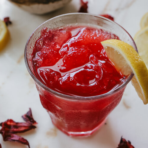 Honey hibiscus lemonade recipe served over ice in a clear glass.