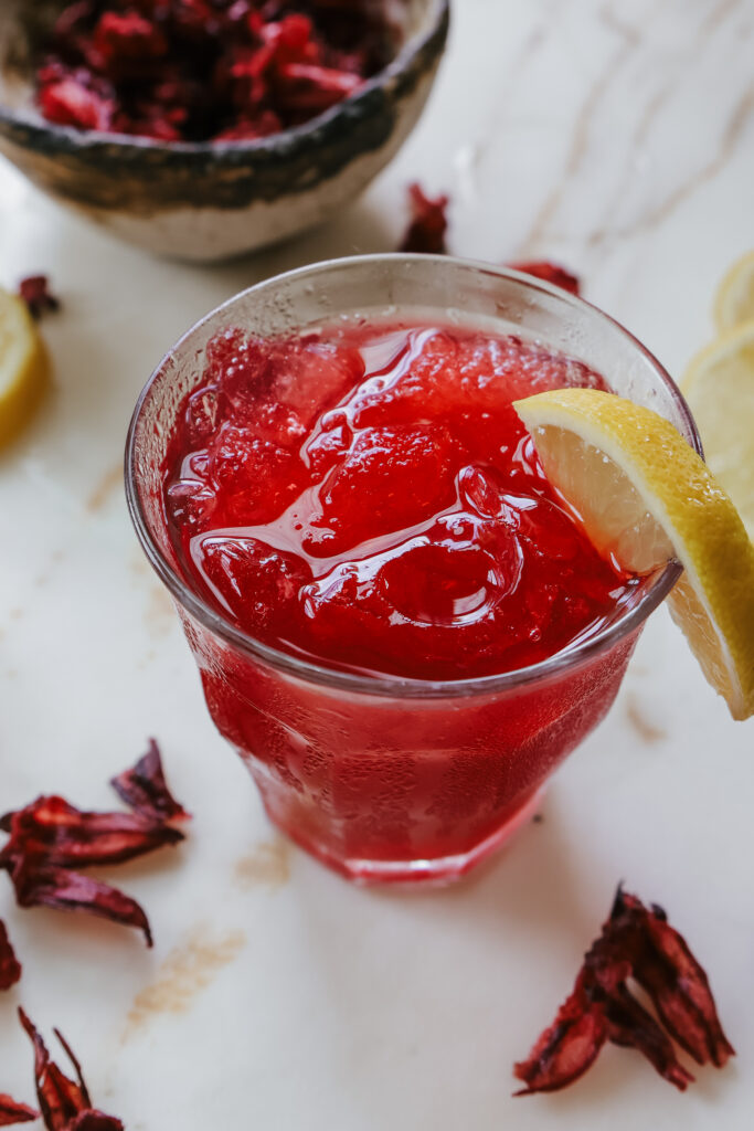 Honey hibiscus lemonade recipe served over ice in a clear glass.