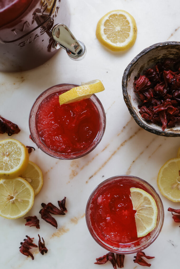 A refreshing ruby red drink garnished with fresh lemon slices.