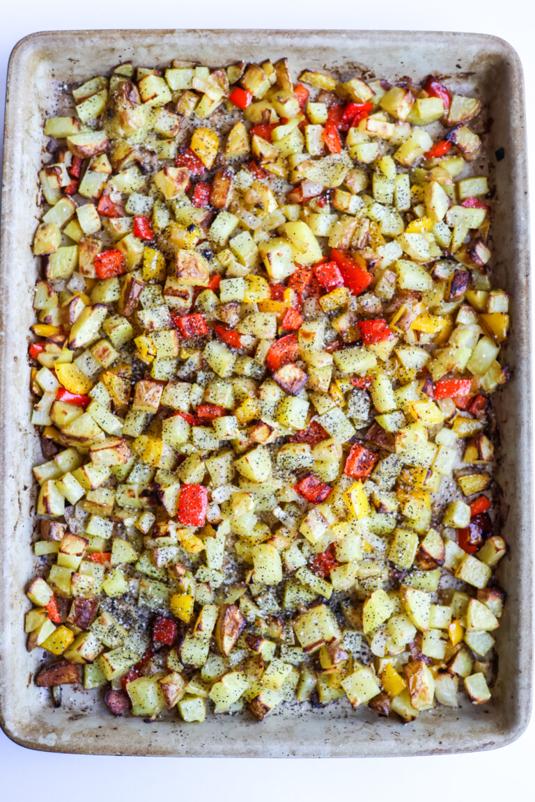 Sheet pan breakfast potatoes with red and yellow bell peppers roasted on a rimmed baking sheet