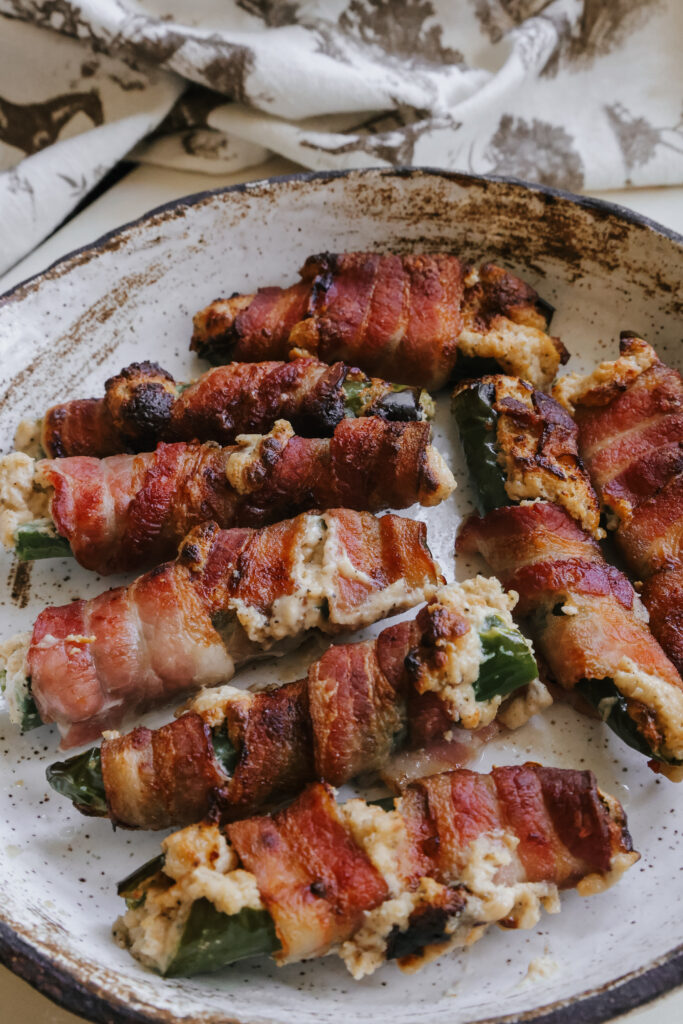Overhead close-up of air fryer jalapeno poppers with bacon crisped and cheese filling exposed