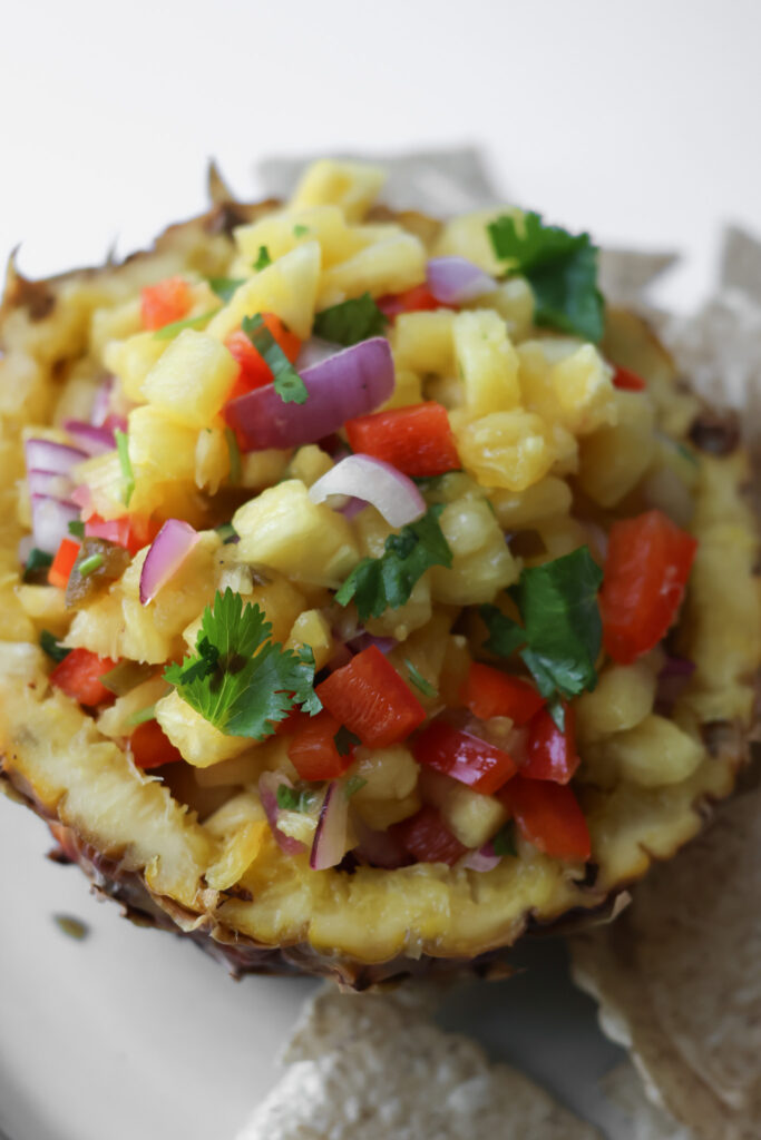 Fresh pineapple salsa recipe served in a hollowed pineapple bowl with tortilla chips