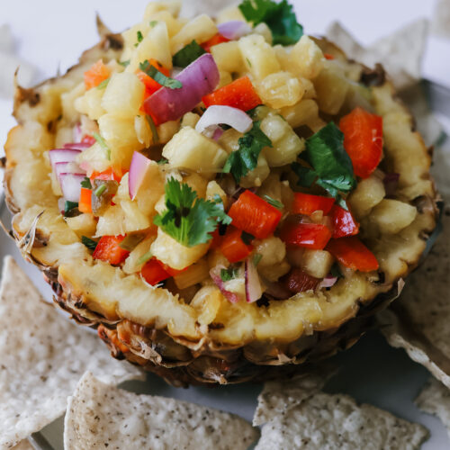 fresh pineapple salsa showing diced pineapple, peppers, and cilantro with chips for dipping