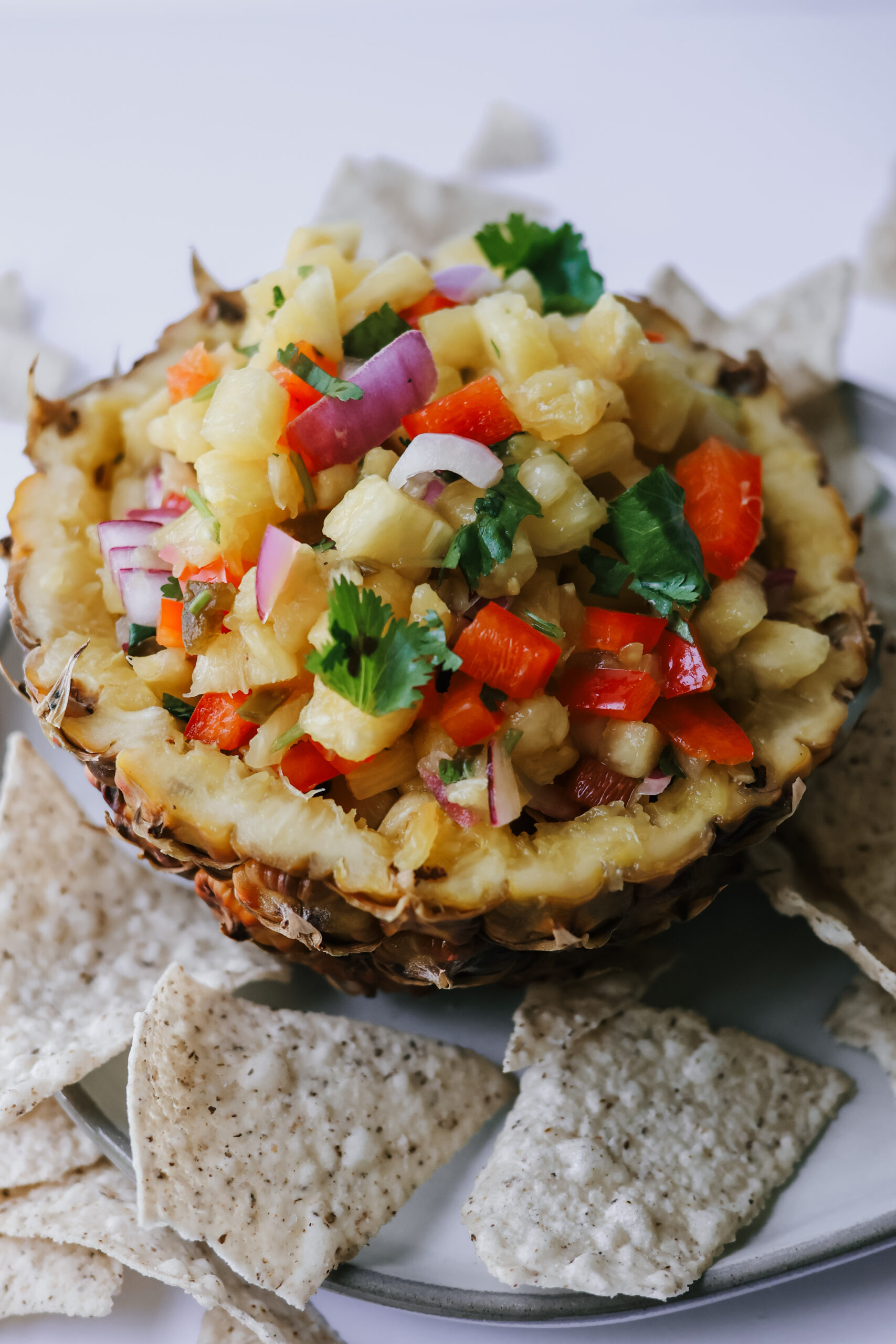 fresh pineapple salsa showing diced pineapple, peppers, and cilantro with chips for dipping