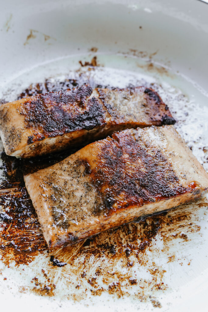 Close-up of pan fried brown sugar salmon showing the caramelized, golden-brown crust