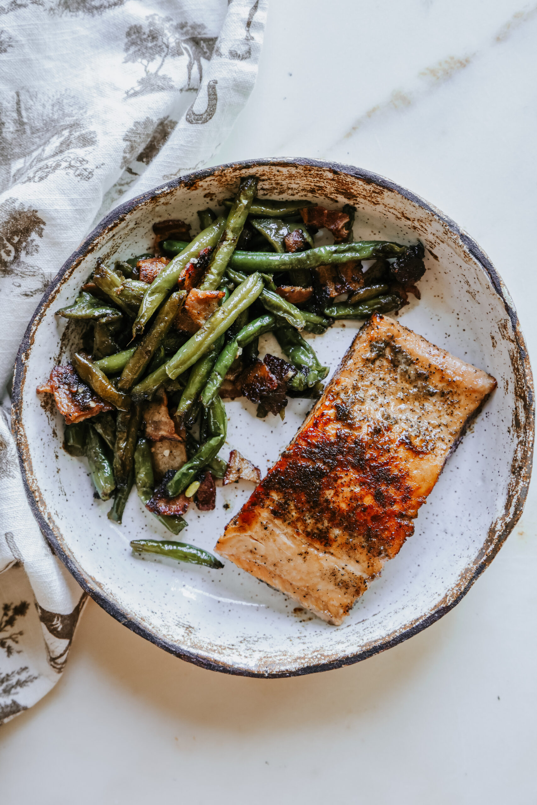 Plated brown sugar salmon recipe served with bacon green beans, top-down view