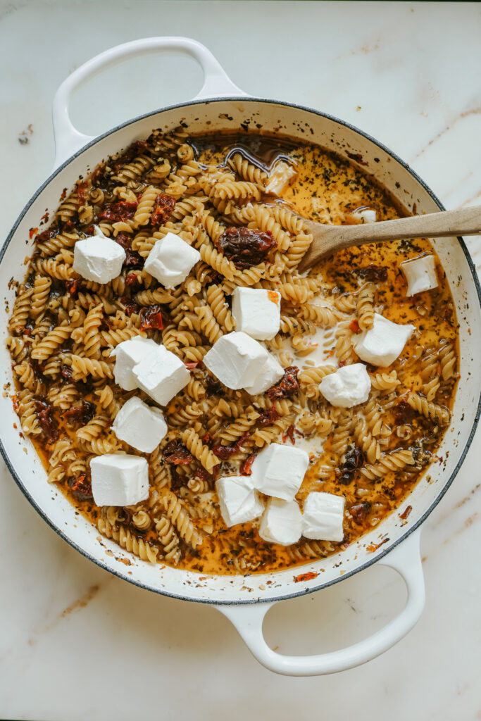 Cubes of cream cheese added to skillet pasta with sun-dried tomatoes